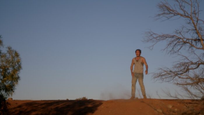 Angela Cerasi's colour grade of a dirty and disheveled man standing in a desolate Australian landscape for the feature film Locusts