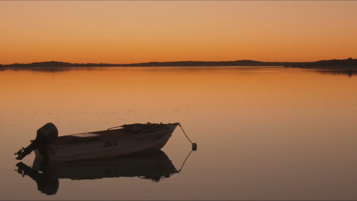 Brisbane Colourist Angela Cerasi did the colour grade on this shot of a small boat anchored in the water, everything lit orange in the sunrise, for the "Drive the Dream with Daniel Ricciardo" TVC campaign for Tourism Western Australia