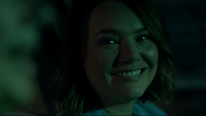 Angela Cerasi's green tinged colour grade of a woman in her car, smiling as tears stream down her face