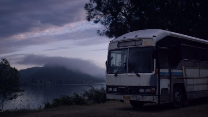 Angela Cerasi's colour grade of an old, rusty bus parked at a lake at dawn, for "Patricia Moore"