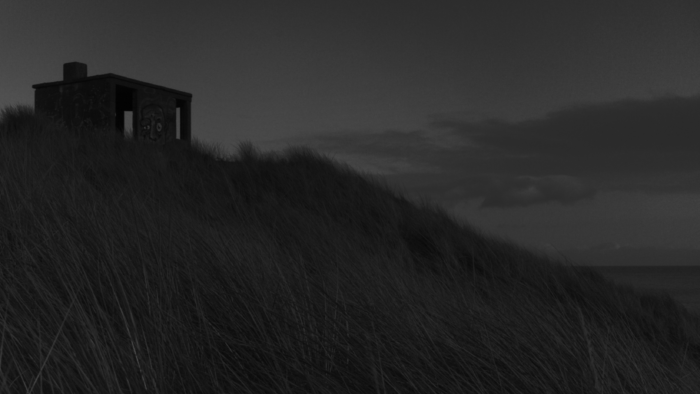 Peachy Keen Colourist Angela Cerasi colour graded this grey-scale shot of a small structure on a grassy hill near the beach, for the music video for the song "Wasteland" by the musician Mick Flannery, directed by Sinéad McDevitt